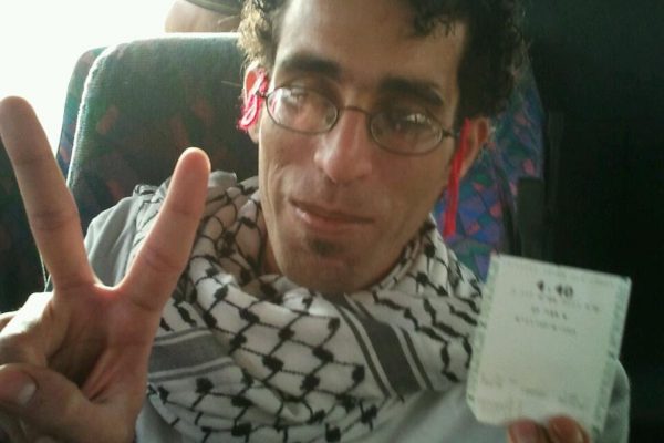 באסל אל אערג׳ מציג כרטיס אוטובוס אותו קנה, מתו פעילות של Freedom Riders- פלסטינים עולים על אוטובוס מתנחלים העובר בתוך הכפרים הפלסטינים למרות האיסור על כך (צילום: אלמה ביבלש)