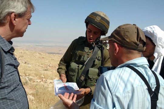 חיילים מציגים צו שטח צבאי סגור בפני פעילי תעאיוש במטרה למנוע מהם ללוות רועי צאן למרעה (אורלי נוי)