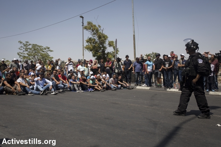 צעירים יושבים על הכביש מול מחסום משטרתי, בכניסה לשכונת וואדי ג׳וז, בסיום תפילת יום השישי 28.7