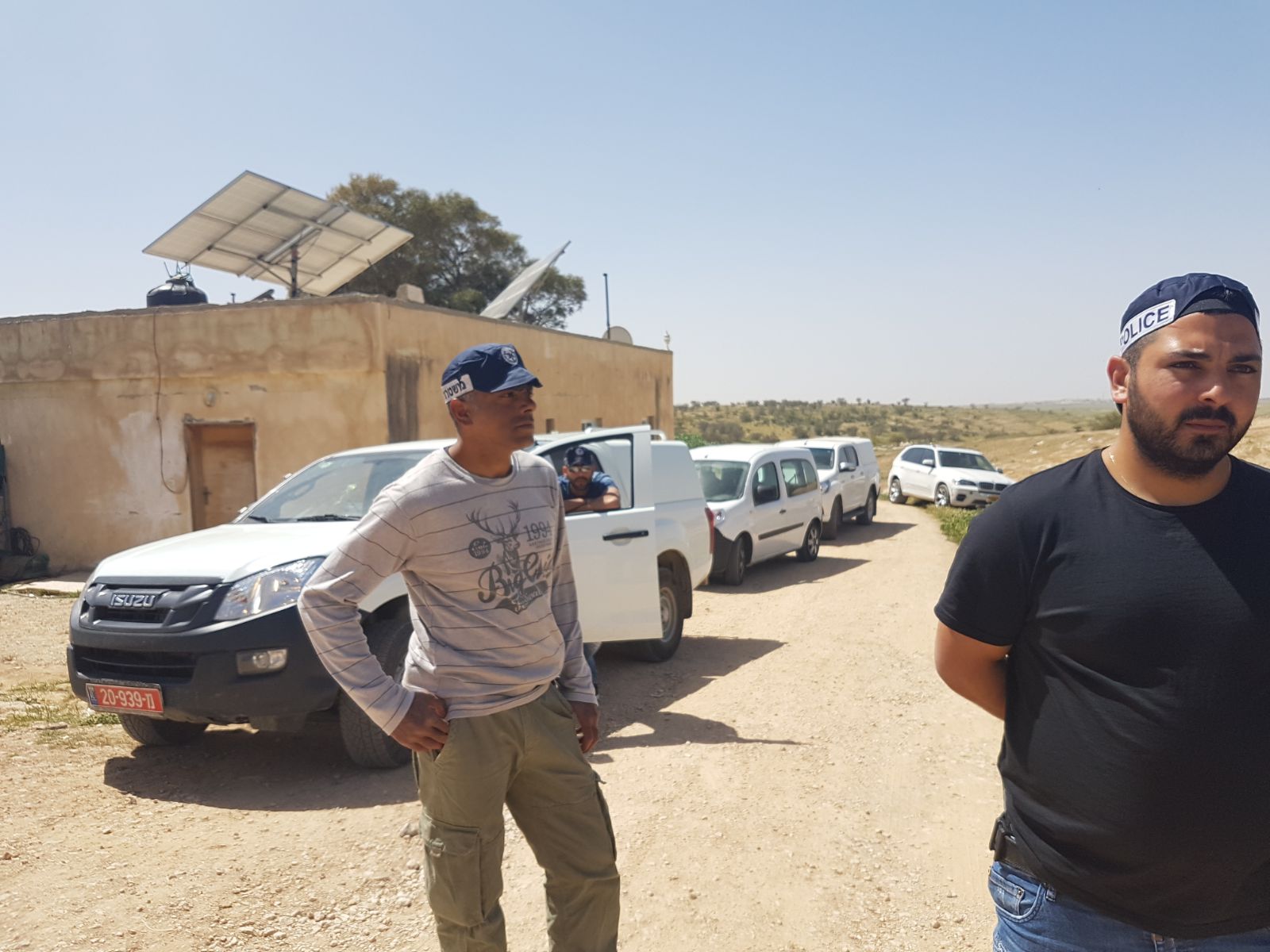 שוטרים מלווים את אנשי רשות מקרקעי ישראל לחלוקת צווי פינוי והריסה לכל מבני ותושבי הכפר. 21 במרץ 2018 (רא'אד אבו אלקיעאן)