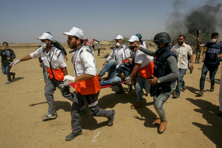 חובשים נושאים עיתונאי שנפצע במהלך הפגנות השיבה בגבול עזה. (עבד רחים ח'טיב / פלאש90