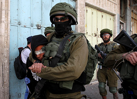 חיילים מובילים עצור פלסטיני בחברון. התמונות האלה כבר נצרבו בתודעה העולמית (צילום: ויסאם השלמון/פלאש90)