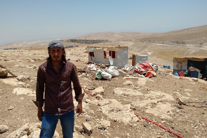 חרבה חמאדין על רקע הריסות ביתו באבו נוואר. "זה יהרוס את כל הקהילה שלנו" (צילום: אורלי נוי)