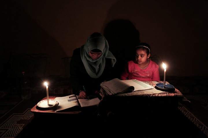 ילדה בעזה עושה שיעורי בית לאור נרות. מחנה הפליטים רפיח, פברואר 2018 (עבד רחים ח'טיב / פלאש 90)