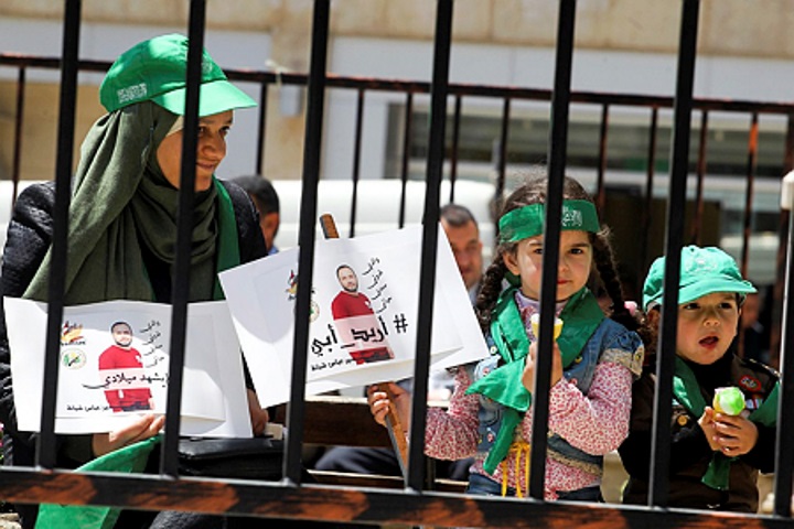 בנותיו של אסיר פוליטי מפגינות בחברון למען שחרור האסירים, 2017. אחת הילדות מחזיקה בתמונתו של אביה עם הכיתוב "אני רוצה את אבא" (ויסאם השלמון/ םלאש 90)