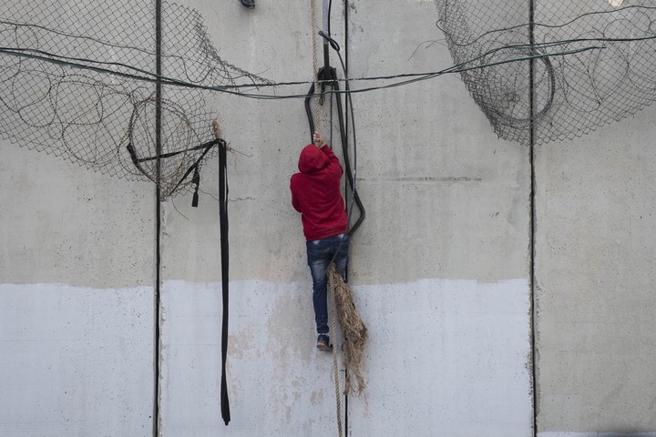 מהצד השני של החומה, הם השתלשלו בחבל, מהר לפני שהשוטרים יגיעו. (צילום: אורן זיו / אקטיבסטילס)