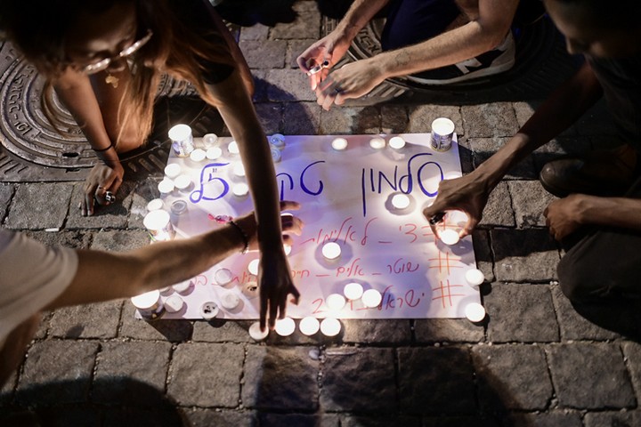 צעירים מדליקים נרות לזכרו של סלומון טקה. 2 ביולי 2019 (תומר ניוברג / פלאש 90)