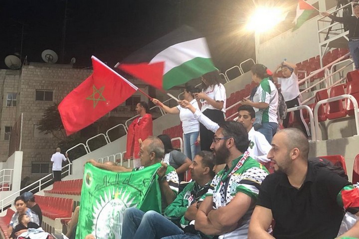 כשהמרוקאים הבקיעו גול, גם האוהדים הפלסטינים קפצו ביציע. אוהדים מניפים דגלי מרוקו ופלסטין ביציע במשחק בין רג'אא קזבלנקה להילאל אלקודס (צילום: סמאח סלאימה)