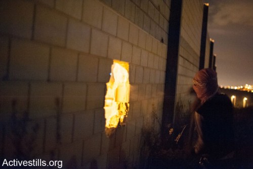פעילים פלסטינים פוערים חור בחומת ההפרדה (צילום: אקטיבסטילס)