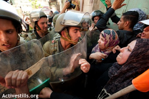 נשים פלסטיניות מפגינות ביום הנכבה, ומולן חיילים. חברון, 2012 (ריאן רודריק ביילר / אקטיבסטילס)