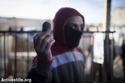 צעיר מציג כדור שחור שנורה לעבר מפגינים בשכונת שועפט. נובמבר 2014 (אורן זיו/אקטיבסטילס)