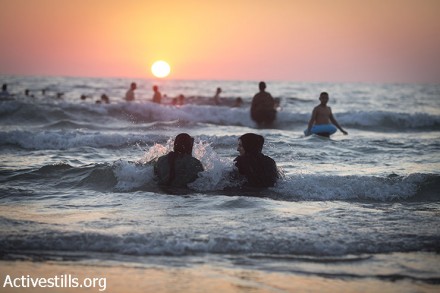 נשים פלסטיניות יושבות בים במהלך היום השני של עיד אל-פיטר, יפו. ביולי, 2015 (אורן זיו/אקטיבסטילס)