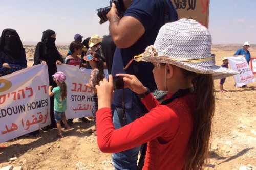בין צלמי העיתונות, אחת ממשתתפות הסדנא מצלמת את ההפגנה באום אל-חיראן. צילום: מיכל רותם, 27.08.2015
