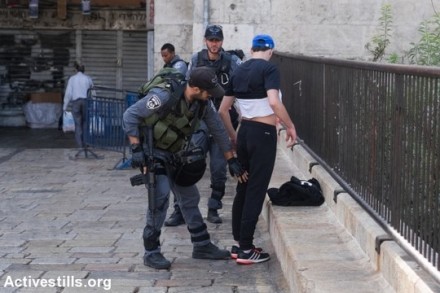 שוטר עורך חיפוש על גופו של צעיר פלסטיני בכניסה לעיר העתיקה בירושלים. 18 באוקטובר 2015. (יותם רונן/אקטיבסטילס)