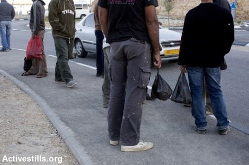 עובדים פלסטינים ממתינים להסעה במחסום ניעלין. אוקטובר 2013. (קרן מנור/אקטיבסטילס)