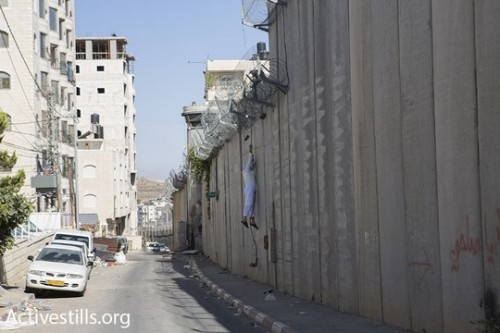 אב וילדיו משתלשלים לתוך בית חנינה בדרך לאל-אקצא, 2015 (אורן זיו / אקטיבסטילס)
