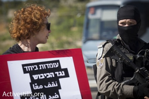 שוטר רעול פנים ומפגינה (אורן זיו / אקטיבסטילס) שוטר רעול פנים ומפגינה (אורן זיו / אקטיבסטילס)