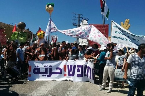 מפגינים במדי אסירים בצעדת החופש ליד מחסום המנהרות (באדיבות לוחמים לשלום)