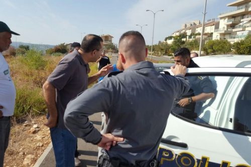 שוטרים עוצרים תושב ראמיה במהלך עבודות לשיקום בית הקברות (יואב חיפאווי)