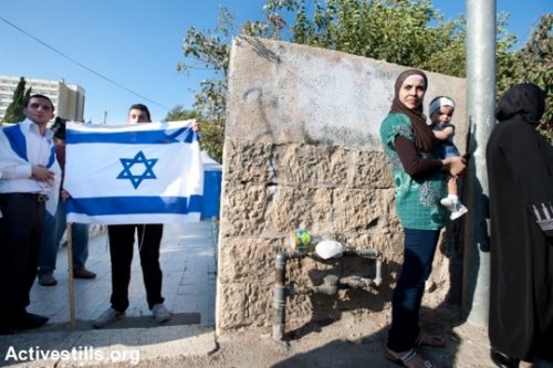 אישה פלסטינית העומדת מחוץ לבית עליו השתלטו מתנחלים בשכונת שייח׳ ג׳ראח בירושלים (ריאן רודריק ביילר/אקטיבסטילס)