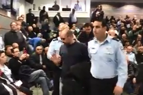 יגאל רמג"ם מפונה מהאירוע לחנוכת תחנתהמשטרה ביפו לאחר שצעק לעבר השר ארדן (צילום מסך מסרטון של רוטר.נט) יגאל רמג"ם מפונה מהאירוע לחנוכת תחנתהמשטרה ביפו לאחר שצעק לעבר השר ארדן (צילום מסך מסרטון של רוטר.נט)