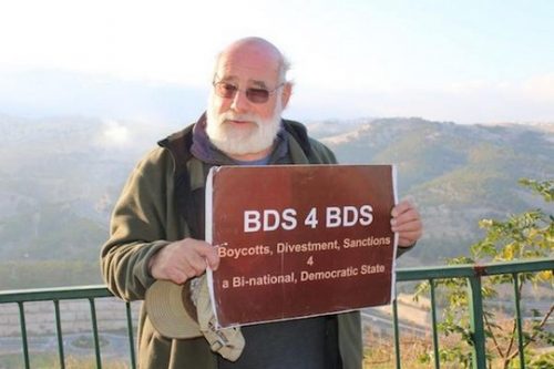 ג'ף הלפר מחזיק בשלט BDS. הלפר לא החזיק את השלט ביום בו עוכב על ידי המשטרה (באדיבות ג'ף הלפר)