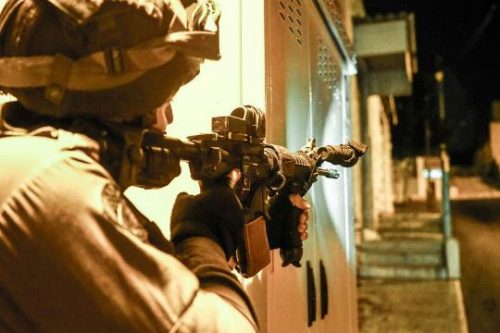 חייל צה"ל דורך את נשקו בכפר פלסטיני בגדה המערבית (צילום: דובר צה"ל) חייל צה"ל דורך את נשקו בכפר פלסטיני בגדה המערבית (צילום: דובר צה"ל)