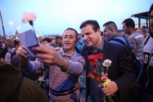 איימן עודה עם פועל פלסטיני בסלפי של אחד במאי במחסום אייל (צילום: חד"ש)