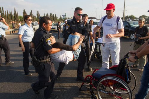 שנה וקללותיה: שוטרים מפנים מפגין על כיסא גלגלים (פלאש90)