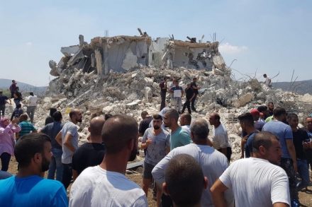 תושבים על רקע הבית ההרוס בסכנין. (צילום: עומר דלאשה, אתר "ערב48")