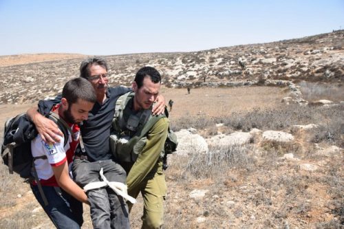 אחד מפעילי תעאיוש מפונה אחרי שהותקף במאחז מצפה יאיר. בהודעת דובר צה"ל לא היה זכר לפעילים שהותקפו ונפצעו (צילום: נסר נאווג'עה / בצלם)