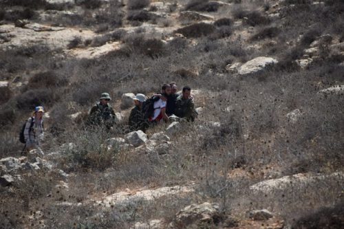 מעלים את אנשי תעאיוש מהמדרון ליד מצפה יאיר. החיילים ראו, ולא ממש התערבו (צילום: נסר נוואג'עה / בצלם)