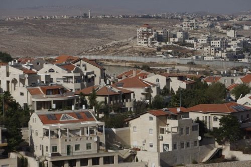 ההתנחלות פסגת זאב וברקע, מעבר לחומת ההפרדה, מחנה הפליטים שועפאט. ספטמבר 2009. (מועמר עוואד / פלאש 90)