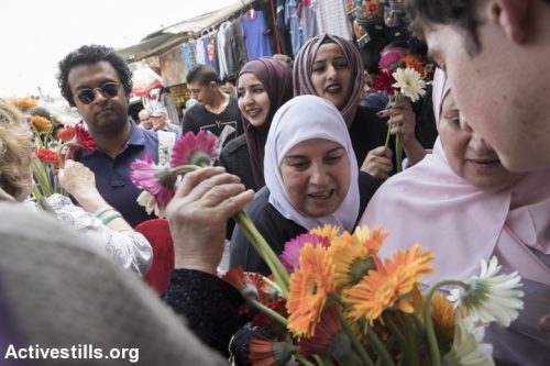 פעילי "תג מאיר" מחלקים פרחים לפלסטינים במהלך "מצעד הדגלים" ביום ירושלים. 14 במאי 2018, ירושלים העתיקה. (אורן זיו / אקטיבסטילס)