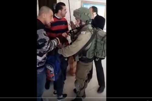 כשהמורים אמרו שמדובר בילד קטן, הקצין ענה: לא משנה הגיל". הקצין, הילד וצוות בית הספר זיאד ג'אבר בחברון הבוקר (צילום מסך מתוך סוכנות מען)