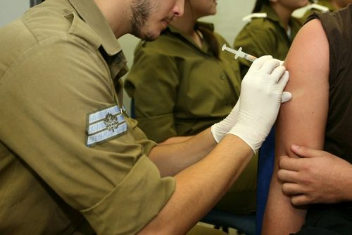 עדיין אין חוק שיגן על חיילים, אסירים ואנשים בבתי אבות מפני ניסויים. חייל מקבל חיסון ביום הראשון לגיוס. אילוסטרציה. למצולמים אין קשר לכתבה. (משה שי / פלאש 90)