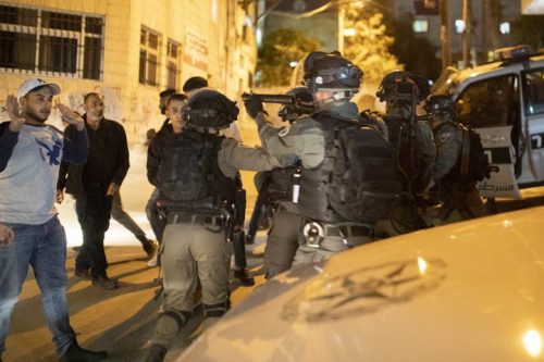 חצי שנה נמשך המבצע בעיסאוויה, ואף אחד בשכונה, וגם חלק מהשוטרים, לא מבינים מה המטרה שלו. שוטר מכוון רובה ספוג לעבר צעיר בעיסאוויה (צילום: אורן זיו)