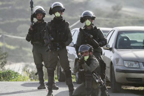 שוטרים לובשים מסכות נגד הקורונה במהלך התנגשויות עם מפגינים פלסטינים בג'בל אל ערמה, ב-11 במרץ 2020 (צילום: נאסר אישתאיה / פלאש 90) שוטרים לובשים מסכות נגד הקורונה במהלך התנגשויות עם מפגינים פלסטינים בג'בל אל ערמה, ב-11 במרץ 2020 (צילום: נאסר אישתאיה / פלאש 90)