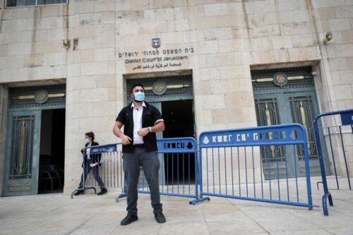 איש אבטחה מחוץ לבית המשפט המחוזי בירושלים, שם עומד ראש הממשלה, בנימין נתניהו, למשפט, ב-24 במאי 2020 (צילום: יונתן זינדל / פלאש90)
