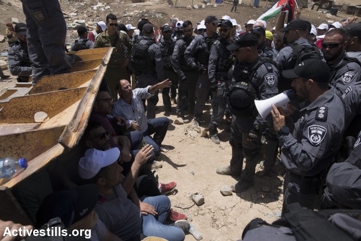 אקטיביסטים פלסטינים, ישראלים וזרים חוסמים בולדוזר ישראלי שמנסה להרוס את הכפר חאן אל אחמר, ב-4 ביולי 2018 (צילום: אורן זיו / אקטיבסטילס)