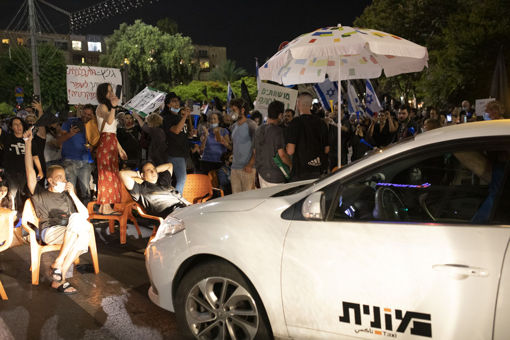 מפגינים חוסמים את רחוב אבן גבירולבמהלך מחאה נגד ״חוק הקורונה״ בתל אביב (צילום אורן זיו)
