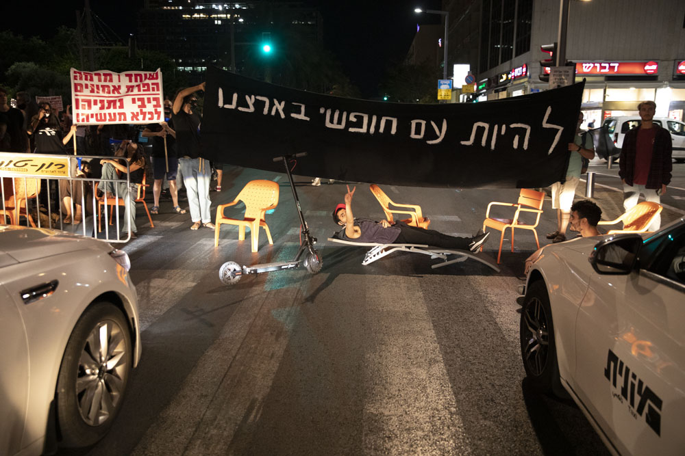 מפגינים חוסמים את רחוב אבן גבירולבמהלך מחאה נגד ״חוק הקורונה״ בתל אביב (צילום אורן זיו)