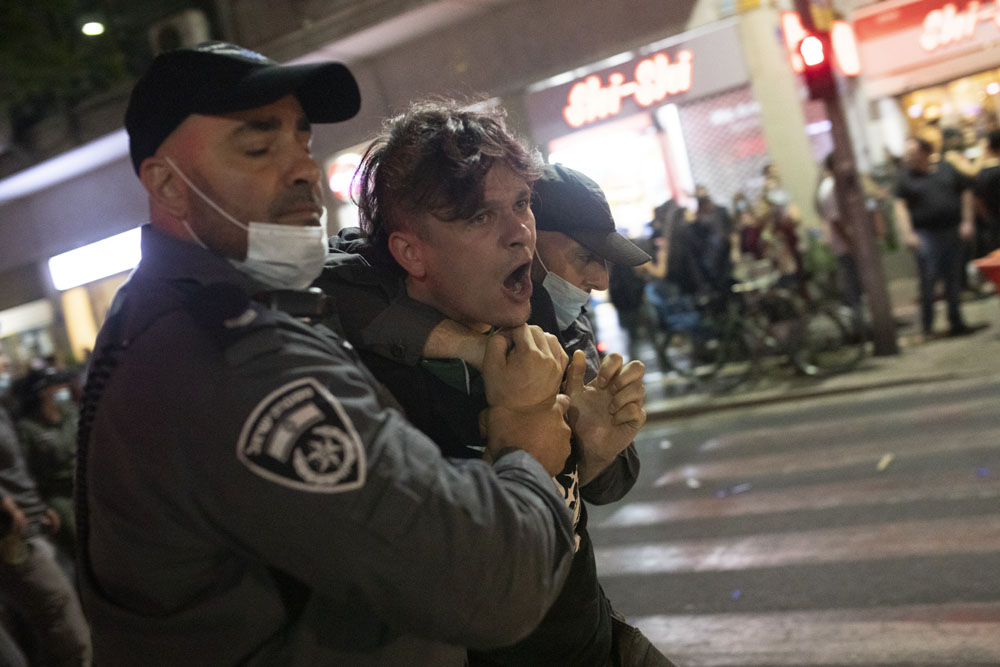 שטורים עוצרים מפגין במהלך מחאה נגד ״חוק הקורונה״ בתל אביב (צילום אורן זיו)