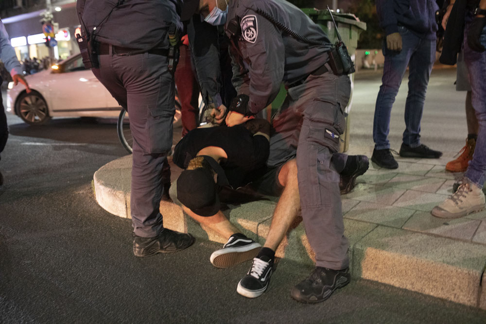 שטורים עוצרים מפגין במהלך מחאה נגד ״חוק הקורונה״ בתל אביב (צילום אורן זיו)