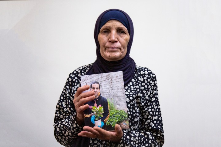 איאד הלך אחריה כמו צל. רנא אלחלאק, אמו של איאד, ששוטרים ירו בן למוות בירושלים, עם תמונת בנה (צילום: אקטיבסטילס)