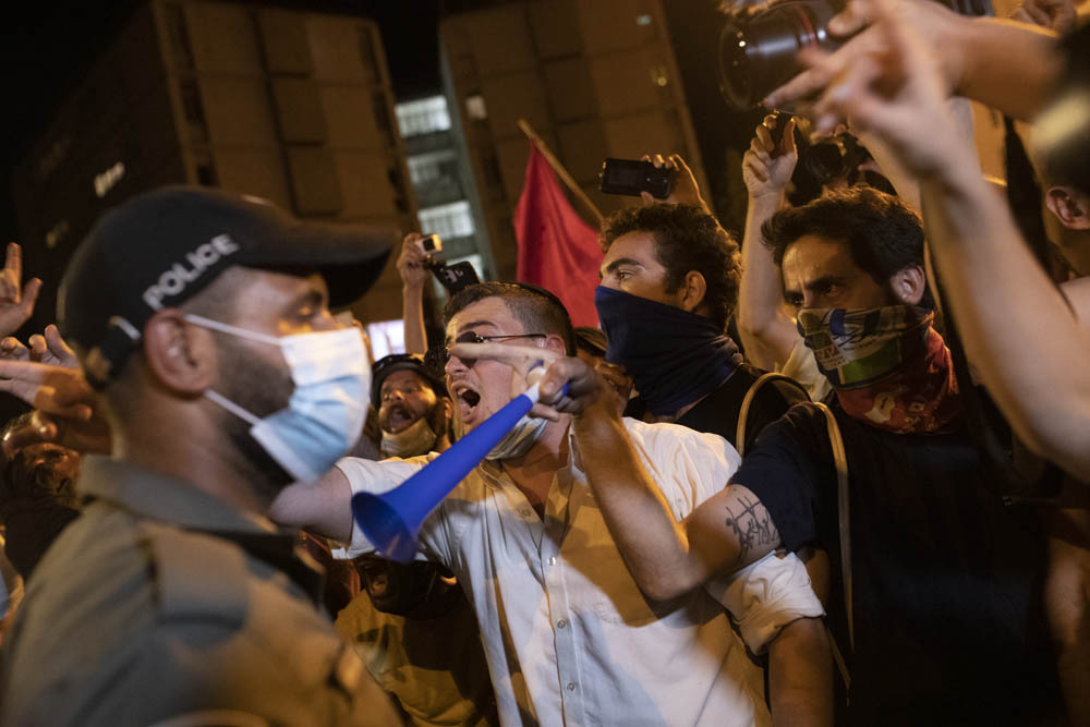 מפגינים מול שוטרים בכיכר פריז, סמוך למעון ראש הממשלה בירושלים, בעזרת תותח מים, 15 ביולי 2020. (צילום: אורן זיו)
