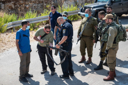 שוטרים וחיילים בוחנים נשק באירוע בו מתנחלים ירו בפלסטינים ליד הכפר בידיא, 5 ביולי 2020 (צילום: שריה דיאמנט\פלאש 90)