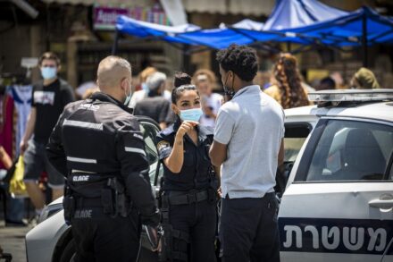 אדם מקבל קנס על אי עטיית מסיכה בירושלים, ב-7 ביולי 2020 (צילום: אוליבייה פיטוסי / פלאש90)