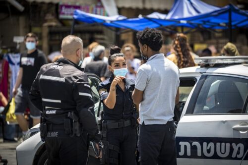אדם מקבל קנס על אי עטיית מסיכה בירושלים, ב-7 ביולי 2020 (צילום: אוליבייה פיטוסי / פלאש90)