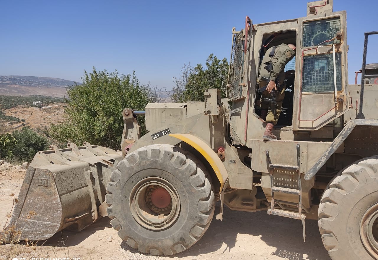 דחפור צבאי עובד על הקמת תלולית עפר בעיירה עסירה א-שמלייה (צילום: חאזם יוסף יאסין)